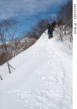 群馬県と新潟県の境目にある日本百名山の冬期谷川岳の天神尾根の登山者と青空 69876395
