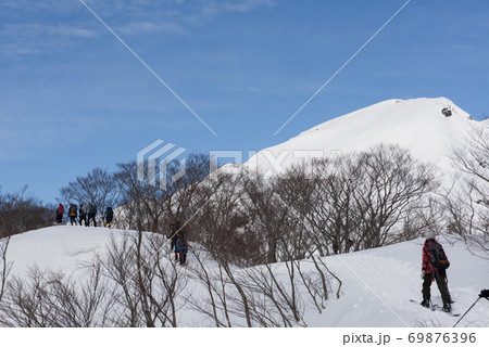 群馬県と新潟県の境目にある日本百名山の冬期谷川岳の天神尾根の登山者と青空 69876396