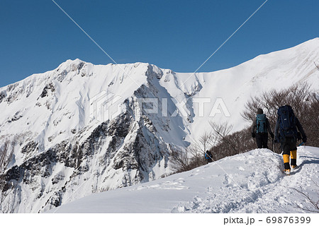 群馬県と新潟県の境目にある日本百名山の冬期谷川岳の天神尾根の登山者と青空の写真素材