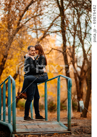 man and woman on bridge over stream in autumn Park man and woman on bridge over stream in autumn Park 69876482