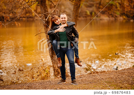 man and woman flirt in autumn park near river. man and woman flirt in autumn park near river. 69876483