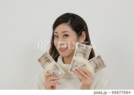 札束を複数持つ女性 69877664