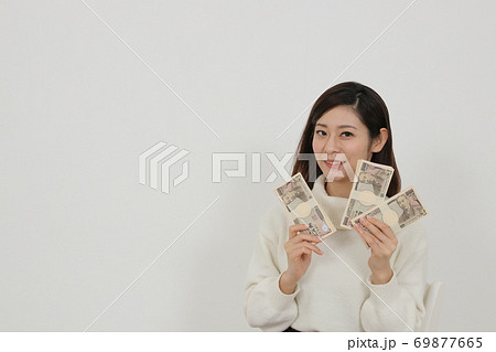 札束を複数持つ女性 69877665