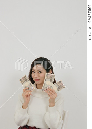 札束を複数持つ女性 69877666