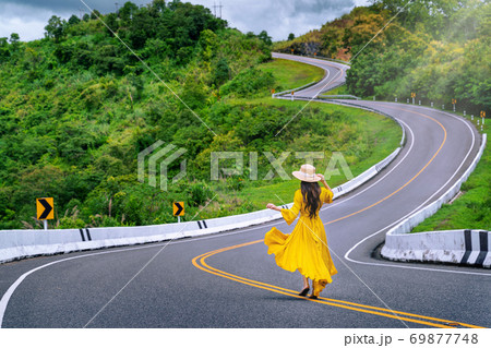 Woman walking on road no.3 or sky road over top of mountains with green jungle in Nan province, Thailand. 69877748
