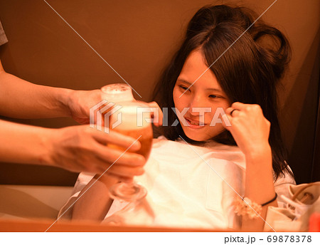 ビールを勧められて苦笑いする若い女性2 69878378