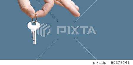 Hand with home key on gray blue background. Hand with home key on gray blue background. 69878541
