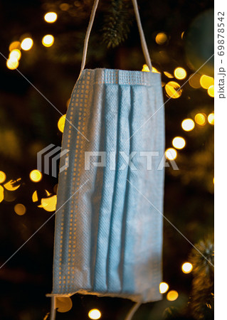 Christmas tree with Coronavirus face mask hanging in tree, decorated with Covid-19 safety mask and Christmas balls for bright Christmas 69878542