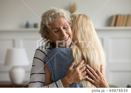 Happy retired mom enjoying cuddles of beloved grownup daughter 69878839