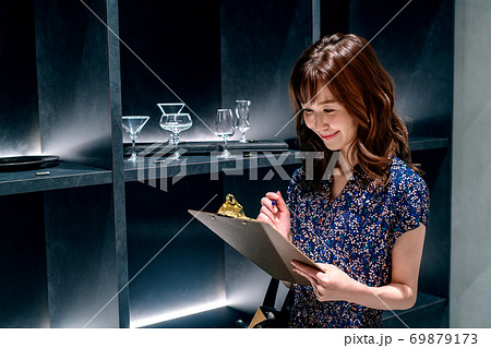 店内で働く書類を持った若い女性スタッフ 店内で働く書類を持った若い女性スタッフ 69879173