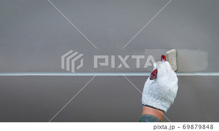 Painting by hand on a cement wall in a straight line Painting by hand on a cement wall in a straight line 69879848