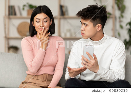 Jealous Chinese Husband Showing Cheating Wife Her Cellphone At Home 69880256