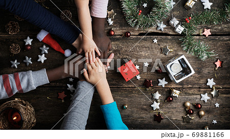 Family of mixed races stacking their hands in Christmas setting 69881166