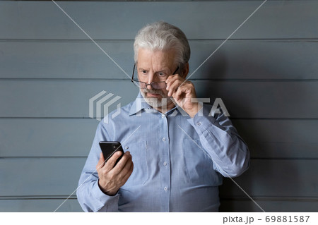 Shocked mature man surprised by unexpected cell message 69881587