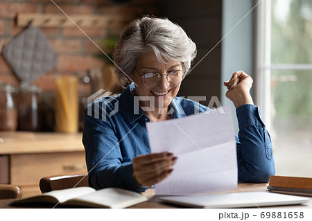 Happy mature woman excited with good news in paper letter 69881658