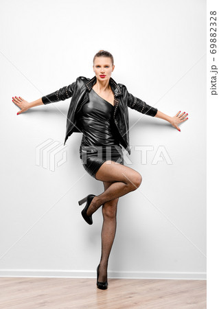 Portrait of pretty woman spreading hands and leaning to the wall 69882328