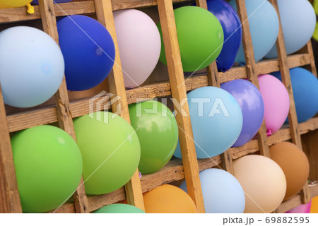 Multicolored balloons in wooden cells. Background from color balloons Multicolored balloons in wooden cells. Background from color balloons 69882595