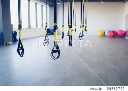 Trx fitness straps for working with own weight in gym, no people 69882722