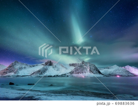 Aurora borealis on Lofoten islands, Norway. Green northern lights above mountains Aurora borealis on Lofoten islands, Norway. Green northern lights above mountains 69883636