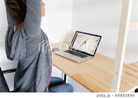 Woman doing stretching yoga at her office by online sport video. Fitness at work. Woman doing stretching yoga at her office by online sport video. Fitness at work. 69883890