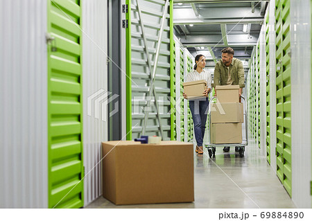 Couple Moving Boxes in Storage Unit Couple Moving Boxes in Storage Unit 69884890