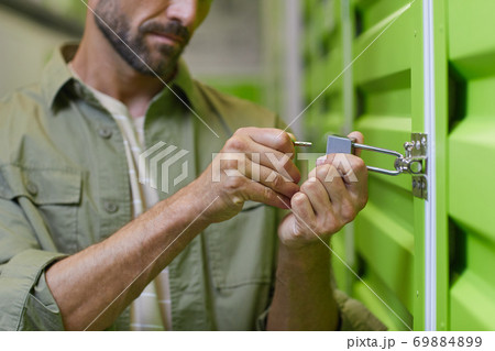 Man Opening Storage Unit Man Opening Storage Unit 69884899