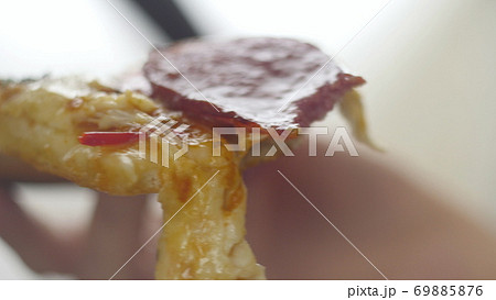 Attractive woman holding slice of pizza and biting it. Hungry girl have a dinner in fast food 69885876