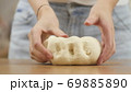 woman on the kitchen table makes domestic food pizza, hands work and pushing stir knead the dough 69885890