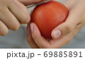Man or woman peels off a tomato with a knife. Preparation of products for cooking 69885891