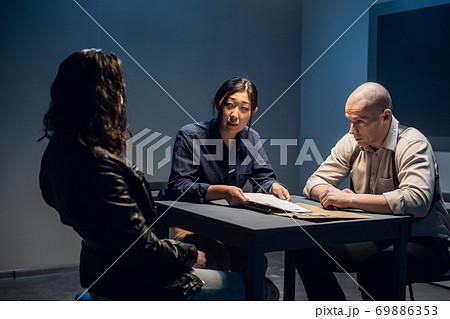 The murder suspect is in the interrogation room with a grim investigator and lawyer. 69886353