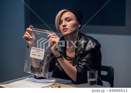 A young girl criminal from a gang was caught with a gun and is photographed with it at a police station A young girl criminal from a gang was caught with a gun and is photographed with it at a police station 69886631
