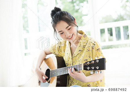 女性　ギター　笑顔 69887492