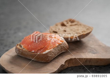 rye ciabatta sandwich with smoked salmon and cream cheese on olive board rye ciabatta sandwich with smoked salmon and cream cheese on olive board 69891005