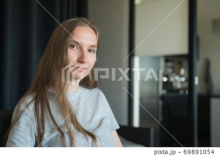 girl sitting on a chair with sunlight from a window girl sitting on a chair with sunlight from a window 69891054