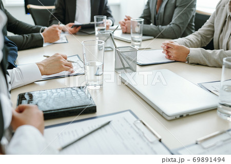 Hands of contemporary business partners over documents in clipboards Hands of contemporary business partners over documents in clipboards 69891494