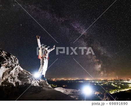 Astronaut standing under beautiful night sky with stars. 69891690