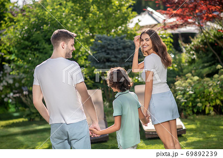 Young family walking in nature on sunny day Young family walking in nature on sunny day 69892239