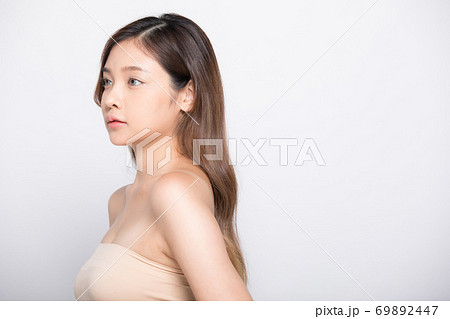 白バックの前でポーズする若い女性モデルの写真素材