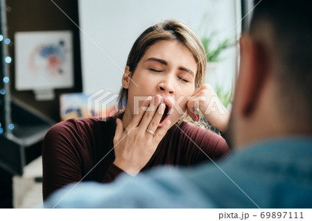 Woman Yawning During Boring Conversation With Partner Woman Yawning During Boring Conversation With Partner 69897111