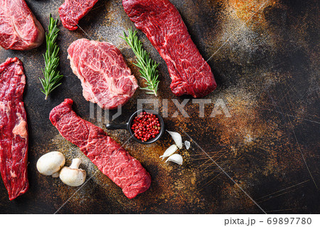 Variety, of raw beef steaks flap flank Steak, machete steak or skirt cut, Top blade or flat iron beef and tri tip, triangle roast with denver cut top view over old rustic metal surface space for text 69897780