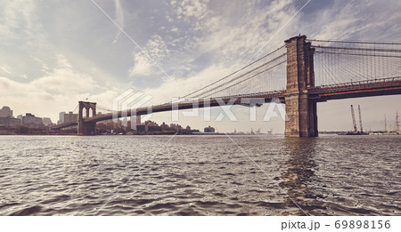 Retro toned picture of Brooklyn Bridge against the sun, New York. Retro toned picture of Brooklyn Bridge against the sun, New York. 69898156