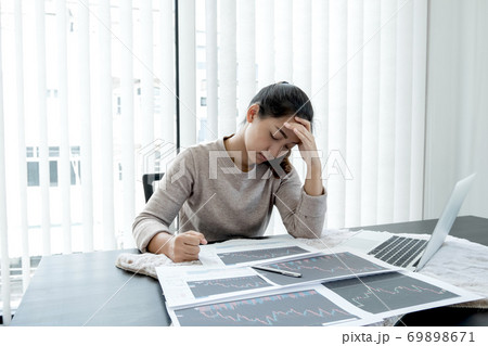 A stockbroker girl has stress, headaches, analyzes, and calculates the stock market that is falling 69898671