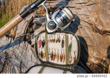 Fishing rod with reel and various kind of baits on the natural background. Fishing rod with reel and various kind of baits on the natural background. 69899402