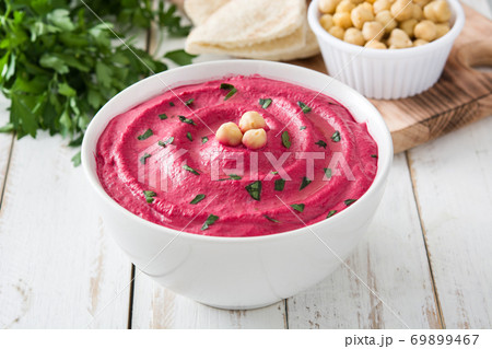 Beet hummus in a bowl on white wooden table	 69899467