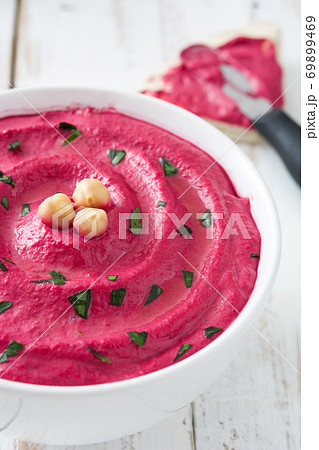 Beet hummus in a bowl on white wooden table	 69899469
