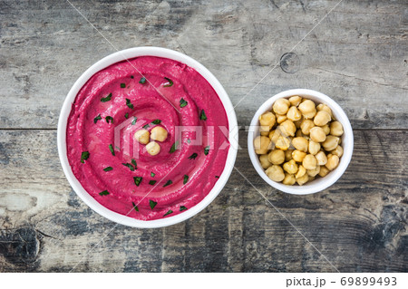 Beet hummus in a bowl on wooden table. Top view. 	 69899493