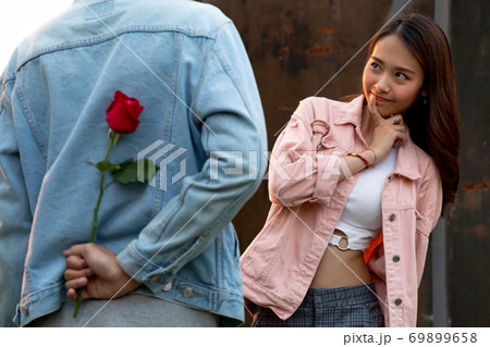 young happy couple love and romantic at first date relationship. asian teenage woman surprise and smiling at boyfriend gives red rose flowers at dinner in valentine day. couple and happiness concept. young happy couple love and romantic at first date relationship. asian teenage woman surprise and smiling at boyfriend gives red rose flowers at dinner in valentine day. couple and happiness concept. 69899658