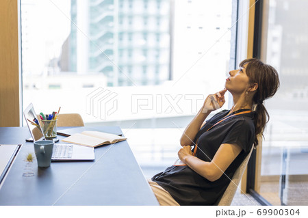 企画書の具体的な案を考えているビジネスウーマン 69900304