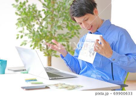 図面を見せながら話すオンラインミーティングの建築士 69900633