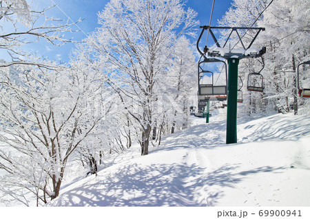 一面銀世界に包まれたゲレンデをリフトで行く【スキー場イメージ】 69900941